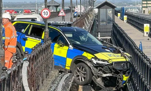 Police car dangling from pier after crash during indecent exposure investigation