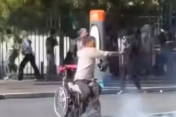 Wheelchair user hurls tear gas canister back at riot police in viral video